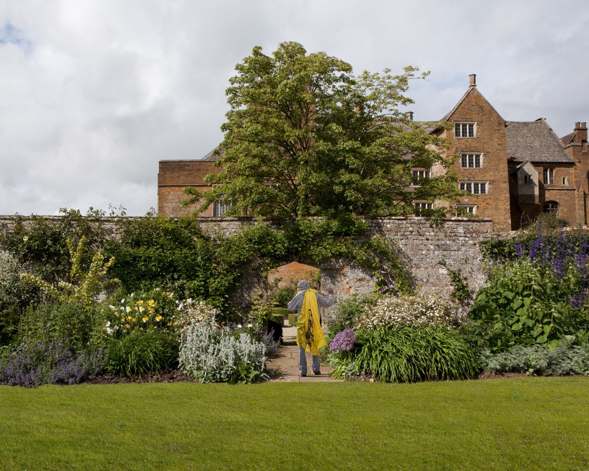 Man in grounds of rurarl English house
