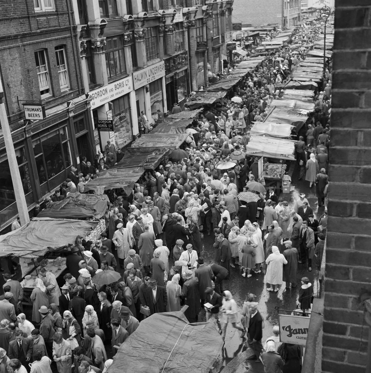 Petticoat Lane Market in the City of London, on a rainy day in the late 1950s-early 1960s.